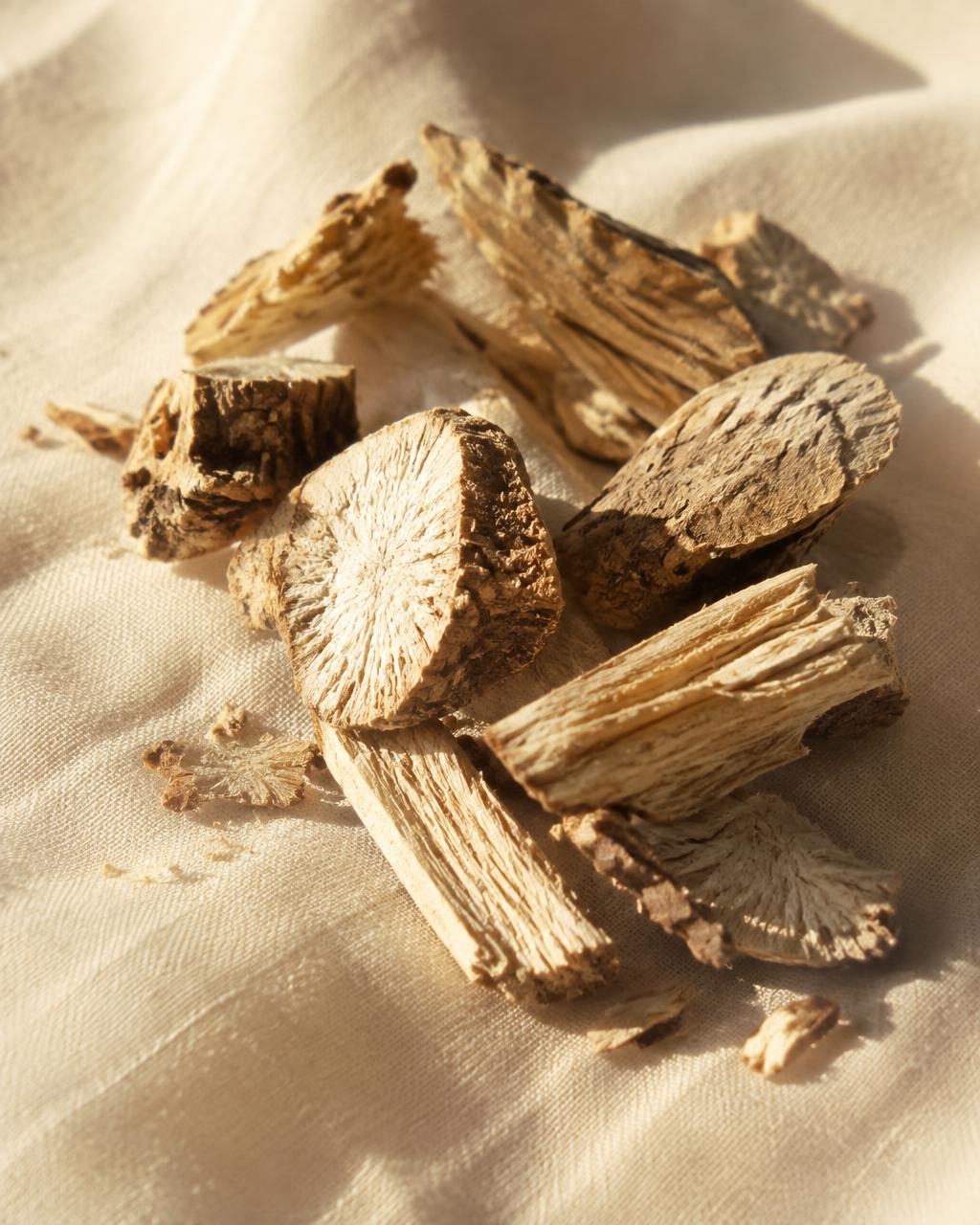 Dried marshmallow root pieces on warm ivory linen